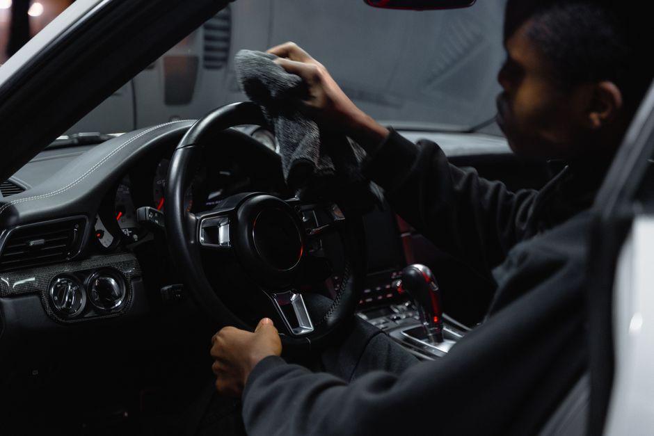 A person wiping down a car interior
