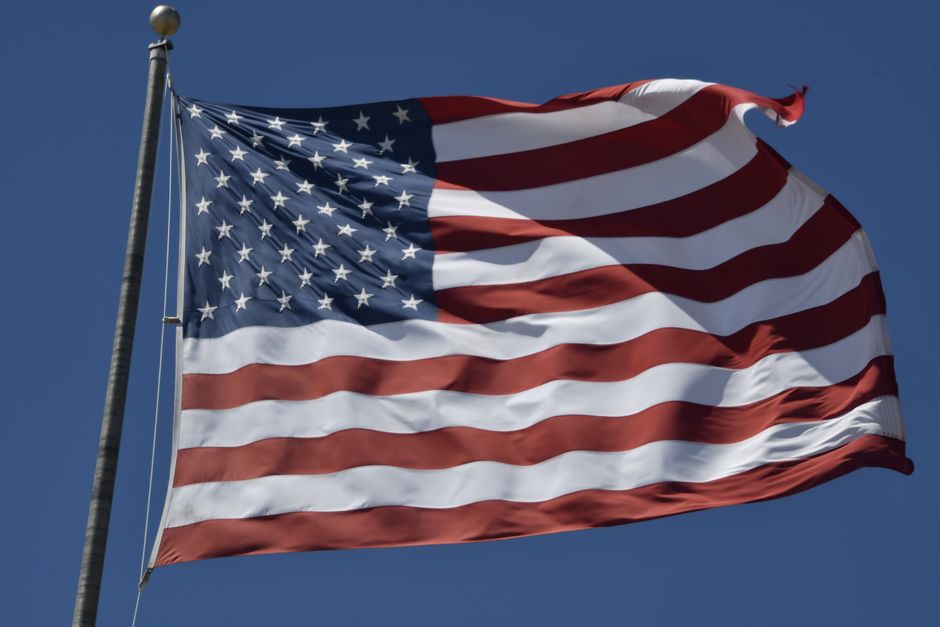 The American flag waving against a clear blue sky